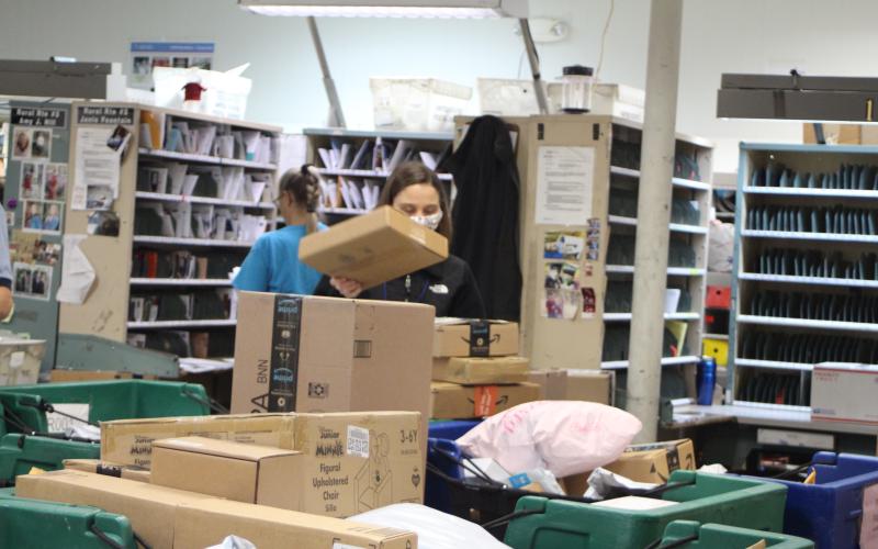 Megan Broome/The Clayton Tribune. Amanda Noffsinger sorts packages at the Clayton Post Office on Monday. The post office is receiving a higher volume of packages than usual for this time of year, receiving an average of 1,000 packages each day, according to Colby Nichols, acting supervisor for the Clayton Post Office.