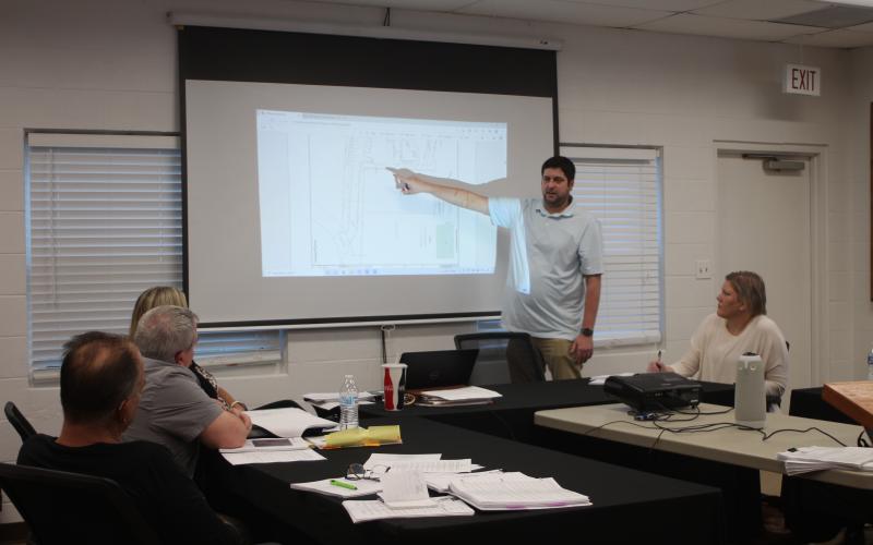 Megan Broome/The Clayton Tribune. Brian Irvin, left, presents renderings of what a short-term rental development planned for Tallulah Falls is expected to look like to zoning board members last Thursday.
