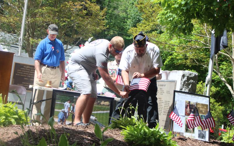File photo. Army Veteran David Cross with Jordan Green places a flag in memory of Veteran David Ramey, who passed away last year, at a Memorial Day ceremony earlier this year.