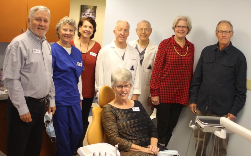 Megan Broome/The Clayton Tribune. Marcia Ranney sits in the new dental chair at the Community Dental Clinic which operates under the Clayton Rotary Foundation, Inc. The chair along with other supplies were provided from a $10,000 grant from the Lake Burton Civic Association Foundation. Also pictured are (from left) Tim Ranney, Sherry Spurr, Amy Hulett, Dr. Brian Davis, Dr. Tom Callahan, Jane Janes, and Jim Wallis from the Lake Burton Civic Association.