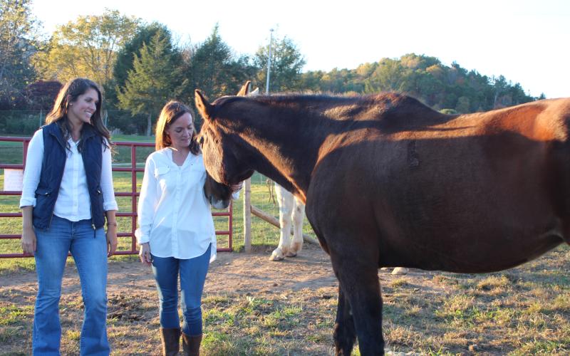 Megan Broome/The Clayton Tribune. Amanda Howard Pileski, licensed psychologist and clinical director of Georgia Mountain Psychological Associates (GMPA), left, and Sunny Volano, licensed professional counselor and director of operations for GMPA, have expanded GMPA services to Londora Valley Farm in Rabun Gap for equine assisted psychotherapy. The goal is for clients to work with horses and help them process and learn to cope with difficult life experiences.