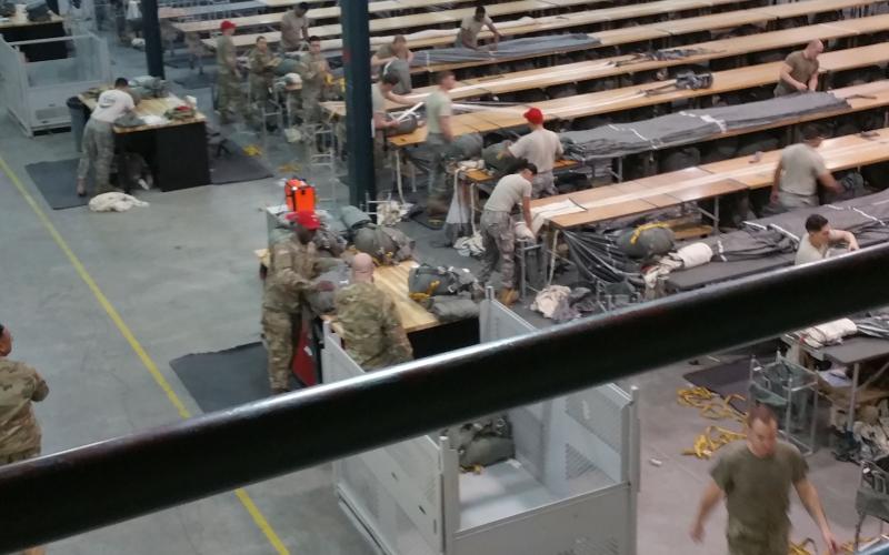 Submitted photos. 82nd Airborne Division Parachute Rigger Pack Section packing T11 parachutes on tables.