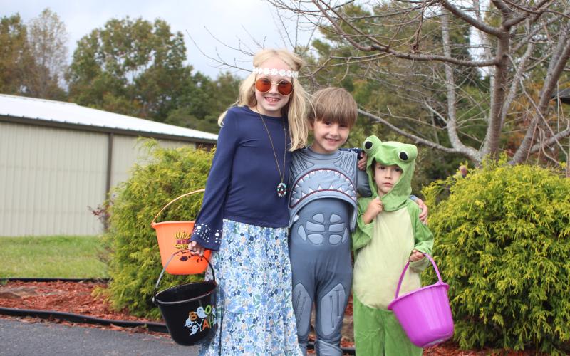 Megan Broome/The Clayton Tribune. Molly Church, 9, left, Miles Church, 6, and Jaxton Church, 3, go Trick or Treating last Saturday.
