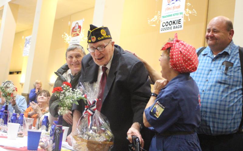 Megan Broome/The Clayton Tribune. Thomas Slowen, left, Carol Cain, dressed as Rosie the Riveter, and Anthony Worley congratulate Korean War Army Veteran Lloyd Hunter, as he is honored at the Veterans Appreciation Dinner held at the Rabun County Civic Center last Thursday. Hunter is 93-years-old and has owned Hunter Funeral Home since 1969. He is part of American Legion Post 220. He also worked in the Coroner’s Office for 52 years.