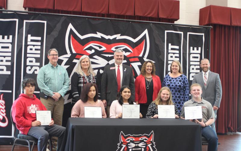 Megan Broome/The Clayton Tribune. Back row: Scott Poss, REACH community partner, superintendent April Childers, Victor Anderson, Georgia State House of Representatives, RCMS principal Kechara Partin, assistant superintendents Kelly McKay and Matt Remillard. Front row: Bobby “Zach” Gordon, left, Vivian Fisher, Sofia Luna Lopez, Alyssa Stancil, and Clayton Scott.