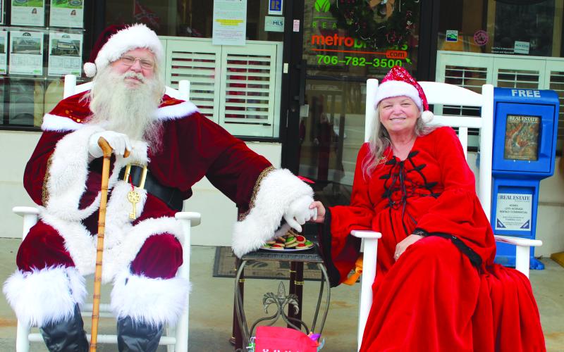 Megan Broome/The Clayton Tribune. Santa Claus and Mrs. Hollie Claus greet children at the Better Homes and Gardens Real Estate company in Clayton on Dec. 17.