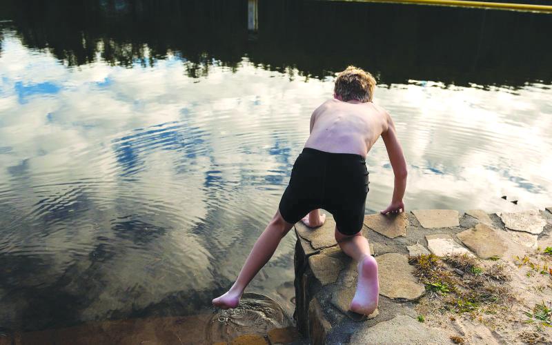 Photo courtesy of E. Lane Gresham. Sixth-grader Caleb Kelley of Demorest dips a toe into the chilly waters of Lake Tallulah on Dec. 15. Kelly, a first-year swim team member, was the first to enter the water for the Tallulah Falls School swim team’s 10th annual “Polar Plunge.”