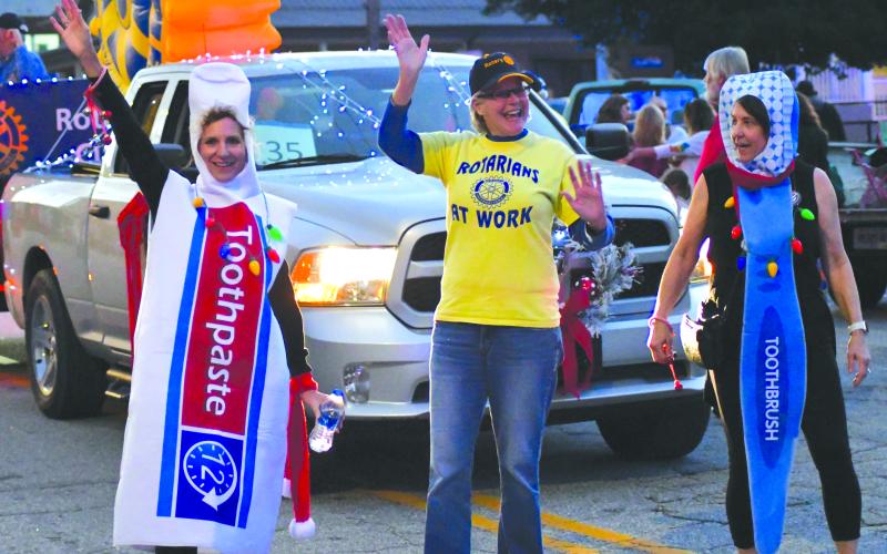 Enoch Autry/The Clayton Tribune. While many of the walkers in the Dec. 4 parade on Main Street passed out candy to children, the Rotary Club of Clayton gave out toothbrushes. Seen here are Katie Penland, Jane Janes and Amy Hulett.