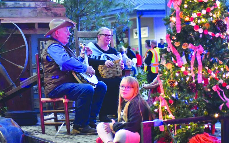 Enoch Autry/The Clayton Tribune. Jim Nixon plays the banjo on the Foxfire - Christmas on the Mountain float with Jessica Parker and JoJo Taylor. The float captured first for “Best Theme.”