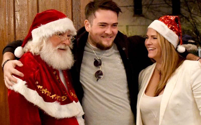Enoch Autry/The Clayton Tribune. Shane Burns and her son Josh share a moment with Santa Claus after the annual parade in the Rock House. The parade theme was “HomeTown.”
