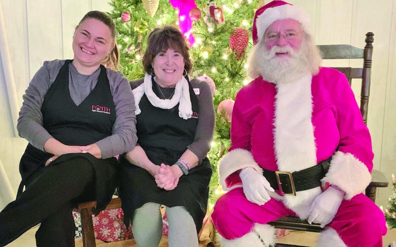 Photo courtesy of Jenifer Kulow/The Clayton Tribune. Dena Crane and Susan Kulow pose with Santa Claus at the Christmas Village of Lights event sponsored by FAITH last weekend. The event continues this weekend. Donations at the event benefit abuse victims.
