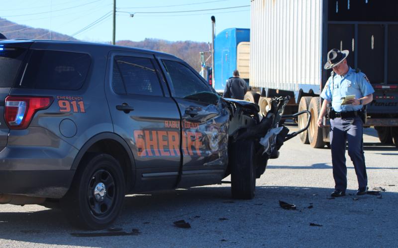 Megan Broome/The Clayton Tribune. A Georgia State Patrol trooper investigates the damage to the Rabun County Sheriff’s Office vehicle. The deputy driving to a scene was not injured in the crash.
