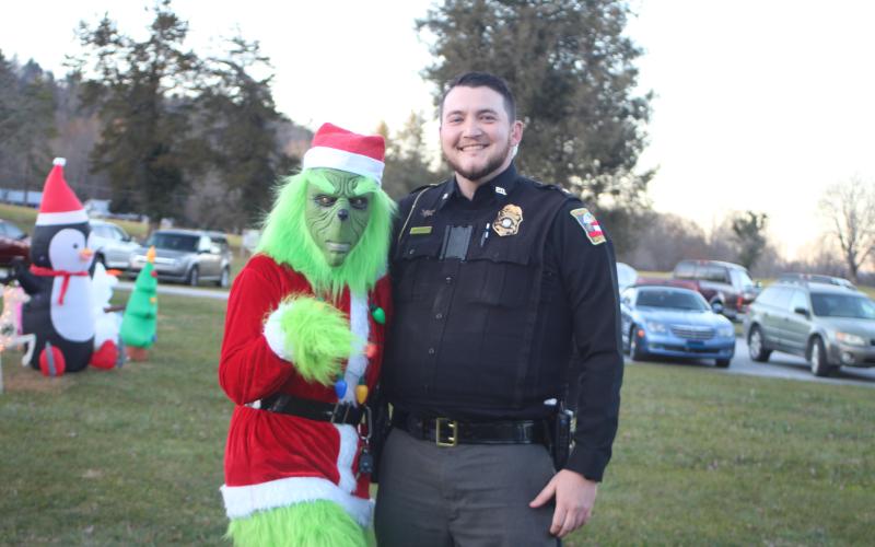 Megan Broome/The Clayton Tribune. The Grinch (Sgt. Victoria Hopper) shows up at the “A Night Out in Christmastown event” in Dillard Dec. 8 to help Police Chief Jeremy Parker, right, spread Christmas cheer.