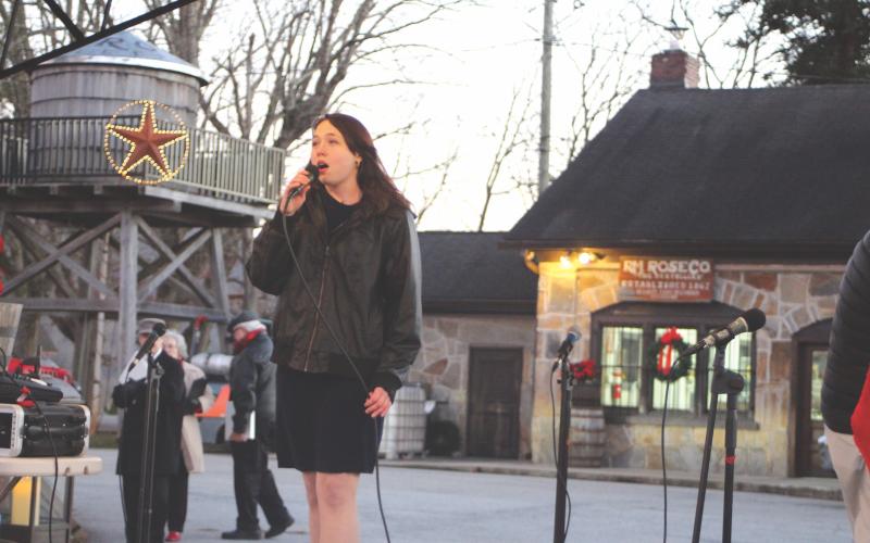 Megan Broome/The Clayton Tribune. Jenifer Kulow sings "Oh Holy Night" at the Dillard gathering.