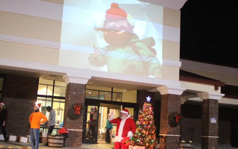 Megan Broome/The Clayton Tribune. Santa passes out candy and gifts to children at the Christmas toy drive held at the Food Bank of Northeast Georgia last Friday.