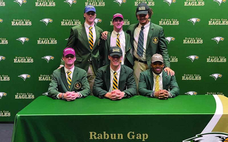 Submitted photo. Six Rabun Gap-Nacoochee School seniors sign letters of intent on Dec. 15 to play collegiately. Five of the Eagles signed to continue their football pursuits at major-college programs, and another signed for baseball. Seated (from left) are Tucker Holloway (Virginia Tech/football), Linus Zunk (Vanderbilt/football) and Buddy Howard (Western Carolina/baseball), while standing are Marlin Klein (Michigan/football), Coleman Bryson (Minnesota/football), and Darren Agu (Vanderbilt/football).