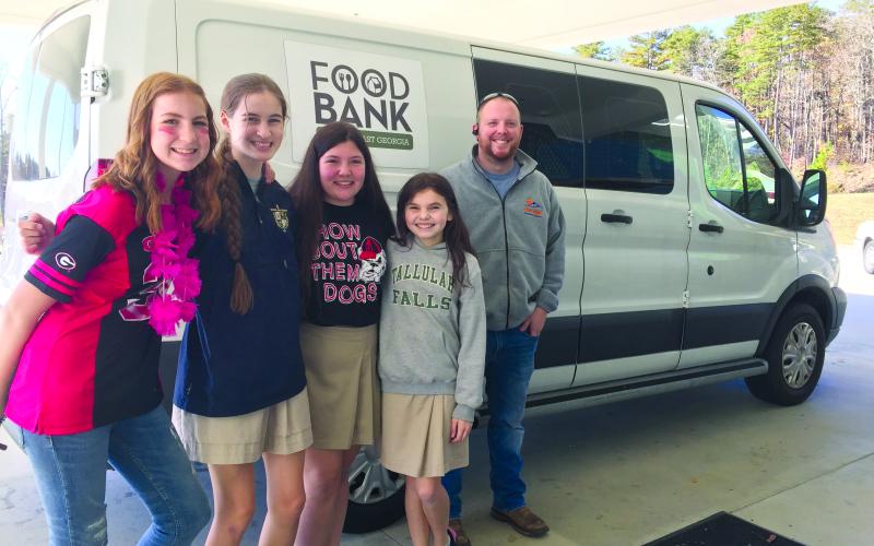 Photo courtesy of Tallulah Falls School. A food drive led by seventh-grade students at Tallulah Falls School generated more than 900 cans for the Food Bank of Northeast Georgia. Shown (from left) are seventh-graders Gracey Eller of Clarkesville, Megan Prince of Rabun Gap, Caylin Tucker of Demorest, Avery Keim of Clarkesville and FBNG Warehouse Coordinator Philip Wilkes.