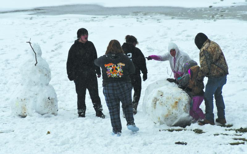 Enoch Autry/The Clayton Tribune. A group creates a second large snowman near the Quality Inn in Clayton Sunday.