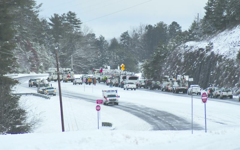 Enoch Autry/The Clayton Tribune. Utility crews work to clear Highway 441 North Monday morning outside the city limits of Clayton.