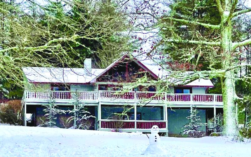 In this photograph provided by Lovett Bennett, a Sky Vally house shows off its winter cottage appeal. The completing touch is the smiling snowman on the front lawn.