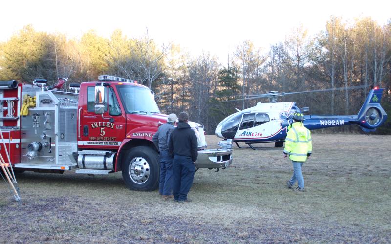 Megan Broome/The Clayton Tribune. A man was transported by Air Life helicopter Tuesday afternoon after attempting to stomp out a brush fire in a filed near the intersection of Highway 246 and Lamb Rd.