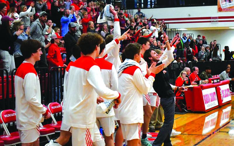 Enoch Autry/The Clayton Tribune. With his Wildcat bench and the Rabun County fans counting down the remaining seconds, head coach David Adcock points skyward as the RCHS boys claim a 67-55 win over visiting Therrell in round one of the Class AA state playoffs.