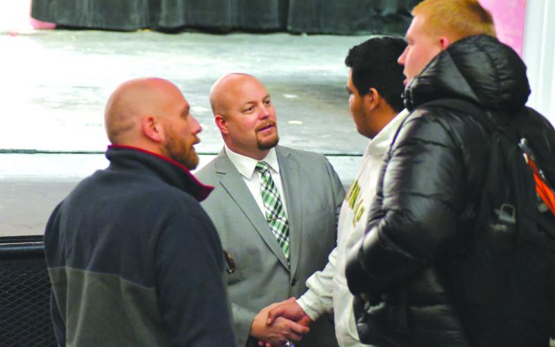 Enoch Autry/The Clayton Tribune. New Rabun Gap-Nacoochee head football coach Derek White (center) talks with his Eagle student-athletes Tuesday morning during an introduction ceremony at the school. White comes to RGNS after guiding five state-title winning football programs.