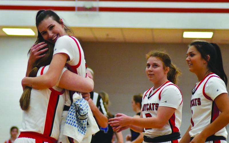 Enoch Autry/The Clayton Tribune. Gracie Deetz receives congratulations from her Ladycat teammates after scoring her 1,000 career point at the Feb. 11 home game against Banks County.