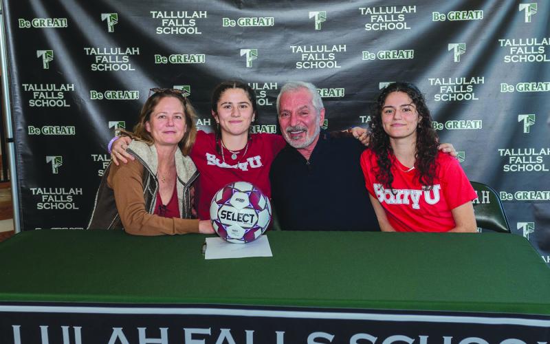 E. Lane Gresham/Tallulah Falls School. Tallulah Falls soccer player Honora Kahwach hugs her mother Kim Newberry and father Joseph Kahwach at the Feb. 9 letter of intent signing with Barry University. Sister Chloe Kahwach is seated on the far right. The senior has been a consistent leader for the Lady Indians.