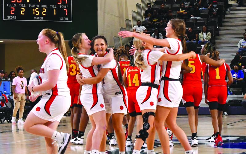 As the final seconds tick off the clock, the Rabun County fans and Ladycat bench come to their feet to celebrate the girls’ 50-39 Class AA Final Four victory as freshman Jacie McCall (14) even shows off her biceps. RCHS plays Elbert County March 10 for the state title.
