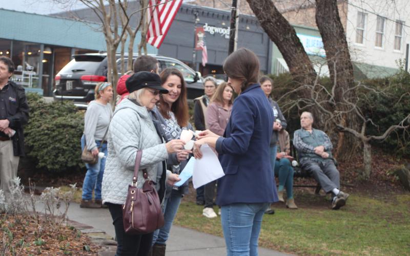 Megan Broome/The Clayton Tribune. Sally Arnold, left, and Amanda Pileski, PhD, of Georgia Mountain Psychological Associates, light a candle at the candlelight service at The Rock House Feb. 22. A candlelight service and Mental Health March hosted by Georgia Mountain Psychological Associates were held to remember those who have lost their lives to mental illness.