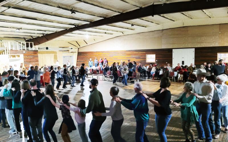 Megan Broome/The Clayton Tribune. Locals and people in neighboring communities came out for the soft opening of the Mountain City Playhouse on March 12. Attendees do the "bunny hop" among a crowd that was standing room only at the venue.