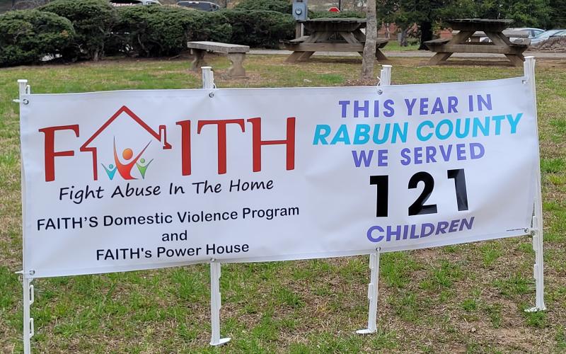 Megan Broome/The Clayton Tribune. April is National Child Abuse Awareness Month and a banner is displayed at the Rabun County Courthouse bringing awareness to the issue and show that 121 children in Rabun County were served by F.A.I.T.H this year.