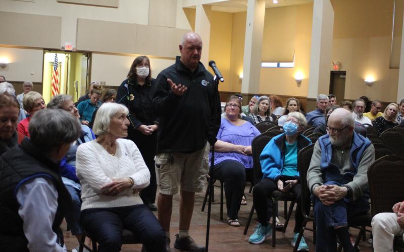 Megan Broome/The Clayton Tribune. Doug Nassaur, owner of Moonrise Distillery in Clayton, asks a question to panelists at the forum held at the Rabun County Civic Center April 21. He asked if the county was consulting with surrounding counties on strategies for managing development. The forum was organized to highlight the need for housing in Rabun County.