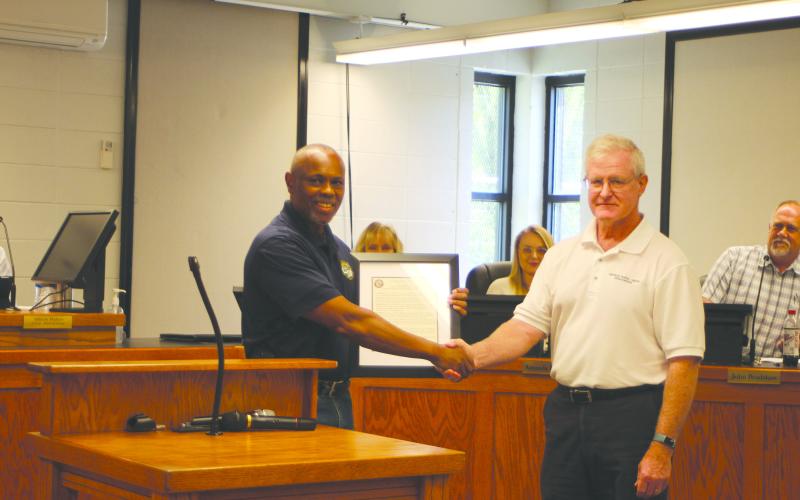 Megan Broome/The Clayton Tribune. Keith Owens, City of Clayton Wastewater Treatment Plant supervisor, left, accepts a Georgia Rural Water Association award for the hard work he and coworker Clint Harbin do for the city, presented by Dennis Brown, energy efficiency and plant organization specialist for the Georgia Rural Water Association.  The award was given after consulting with Brown on how to implement operating strategies at the Wastewater Treatment Plant that would result in energy-saving measures.