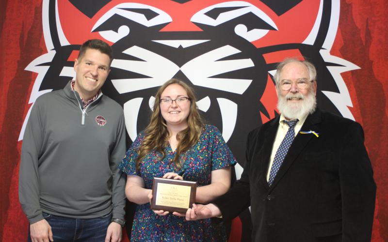 Megan Broome/The Clayton Tribune. RCHS teacher and UNG graduate student Kelsie Burks Mayes, center, is presented with the Appalachian Studies Association 2021 Carl A. Ross Appalachian Graduate Student Paper Award by Dr. Barry Whittemore, lecturer at UNG. RCHS Principal Justin Spillers stands to the left.