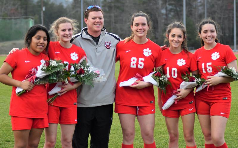 Enoch Autry/The Clayton Tribune. Standing with RCHS girls soccer coach Brad Holcombe are 2022 seniors Bianca Avila, Sasha Hill, Willow Fisher, Kailah Nixon and Zoey Koss after a ceremony to honor the players on “Senior Night” on March 30