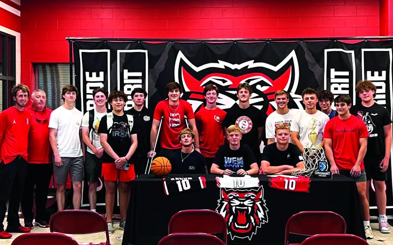 Submitted photo. Surrounded by his teammates, Rabun County senior Gus Hood (seated, center) signs with Covenant College after a solid high school career as a point guard. Hood averaged 13 points a game as a senior.