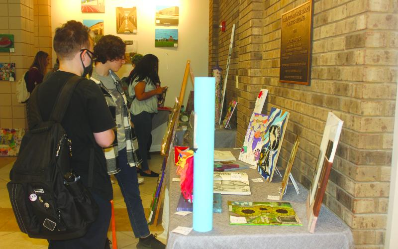 Megan Broome/The Clayton Tribune. Senior Janie Henslee and Eleventh grader Victoria Merino browse the RCHS Student Art Show held in the Fine Arts Building May 13.