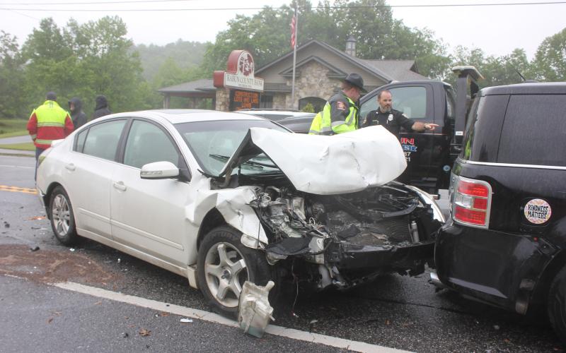 Megan Broome/The Clayton Tribune. Law enforcement officials inspect the damage from a three-vehicle crash that occurred in Dillard Monday.