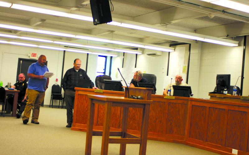 Megan Broome/The Clayton Tribune. Jason Waldroup, public works director for the city of Clayton, and Eric Neese, engineer for the city of Clayton, talk to Clayton council members at a council meeting earlier this year about the need to increase water rates for Clayton water customers. Council members unanimously approved an increase of 20 percent, which Walroup said increases customer monthly bills $5-$10.