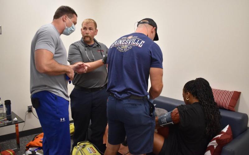 Submitted photo. Gainesville Fire Department Captain and Paramedic, and Clayton resident, Jordan Green, second from left, competes in the 2022 Georgia Police and Fire Games with fellow coworkers. The team took home second place in the Medic Challenge part of the games on June 23. Pictured are Eron Sunshine, program director for paramedic Studies at Lanier Technical College, Green, and Firefighter and Paramedic Josh Crawford, helping an actor during the Medic Challenge.