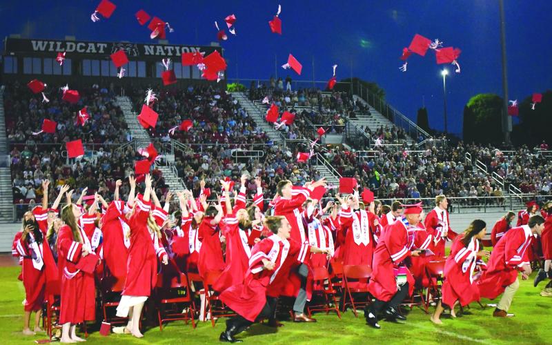 Enoch Autry/The Clayton Tribune. The Rabun County High School graduates of the Class of 2022 throw their caps into the air at the May 27 ceremony at Frank Snyder Memorial Stadium and race to the bell.