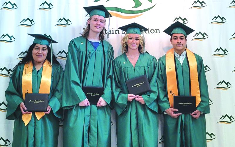 Megan Broome/The Clayton Tribune. Jocelin Lopez, Luke Edward Fowler-Berken, Shaylyn Sondra McGuffin and Andrew Zafra are all smiles as they pose with their diplomas after graduating from Mountain Education Charter High School June 16 at the RCHS FAB building.