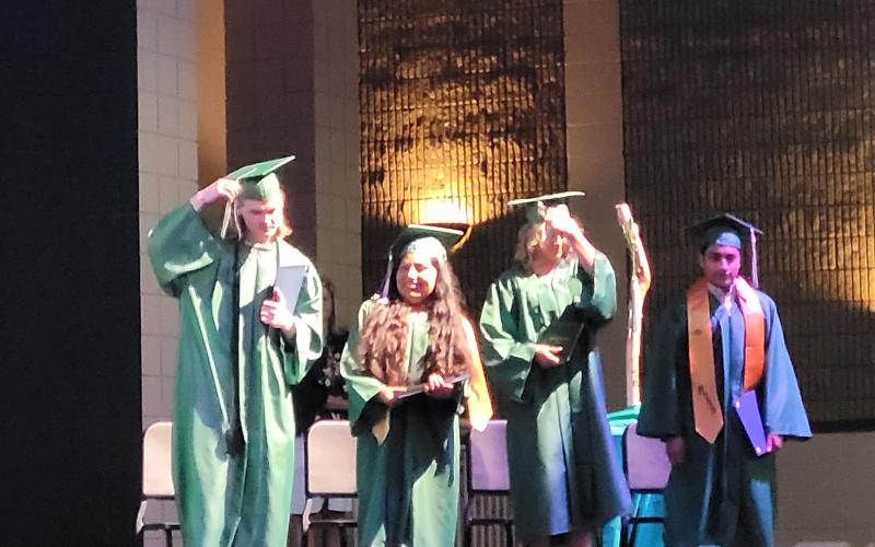 Megan Broome/The Clayton Tribune. Graduates of Mountain Education Charter High School, Jocelin Lopez, Luke Edward Fowler-Berken, Shaylyn Sondra McGuffin and Andrew Zafra, turn their tassels and celebrate on stage in front of friends, family and faculty members after graduating on June 16.