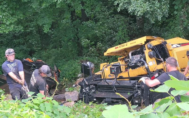 Megan Broome/The Clayton Tribune.  Emergency responders work to remove a vehicle that overturned down an embankment while carrying work equipment on Highway 246 around Winding Ridge Drive in Rabun County June 17.