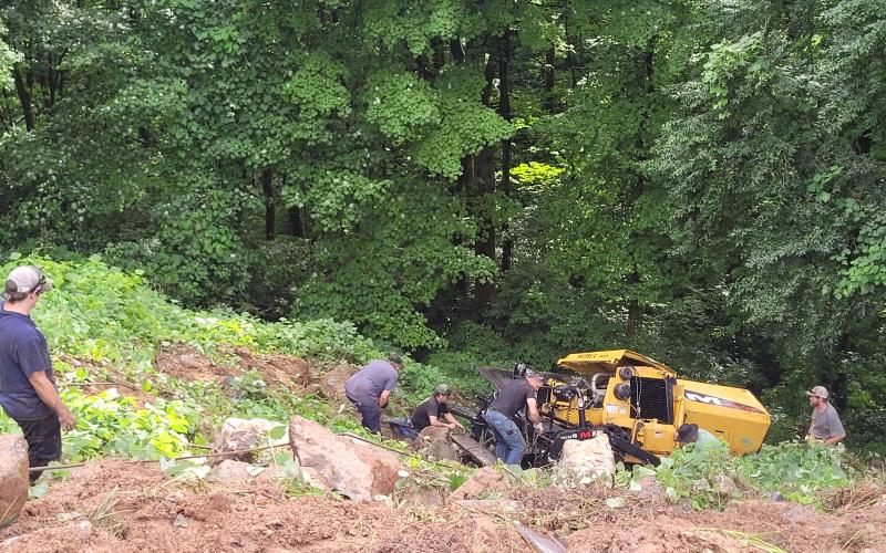 Megan Broome/The Clayton Tribune.  Emergency responders work to remove a vehicle that overturned down an embankment while carrying work equipment on Highway 246 around Winding Ridge Drive in Rabun County June 17.