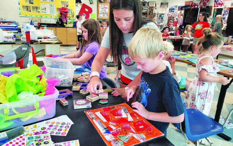 Megan Broome/The Clayton Tribune. Abbye Carver helps 6-year-old Hayes Ward with his art project on July 14 during Art Camp with Mrs. Amy Jarrard, Visual Arts teacher and Fine Arts Department Chair at Rabun County High School.