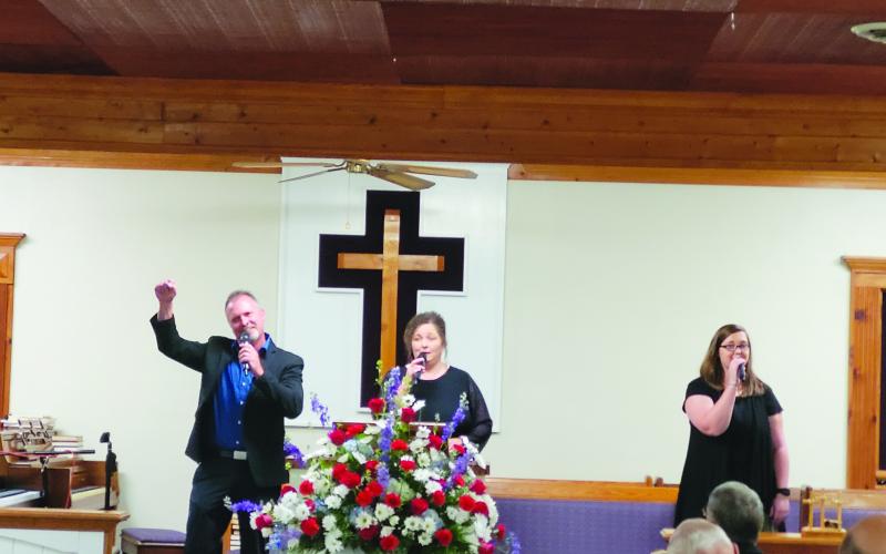 Megan Broome/The Clayton Tribune. Echoes of Mercy from Anderson, S.C., made up of Brian, Laura and Ashley Latham, sing worship music as the guest musicians for Bethel Baptist Church’s 130th Anniversary celebration July 17.