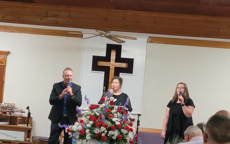 Megan Broome/The Clayton Tribune. Echoes of Mercy from Anderson, S.C., made up of Brian, Laura and Ashley Latham, sing worship music as the guest musicians for Bethel Baptist Church’s 130th Anniversary celebration July 17.